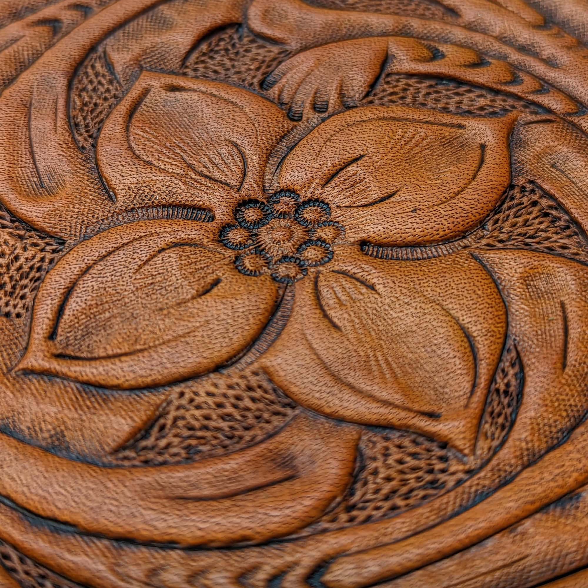 Leather coaster with a tooled flower and vines.